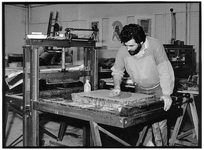 841671 Afbeelding van een lithograaf tijdens het prepareren van een lithosteen in het Grafisch Atelier (Pieterskerkhof ...